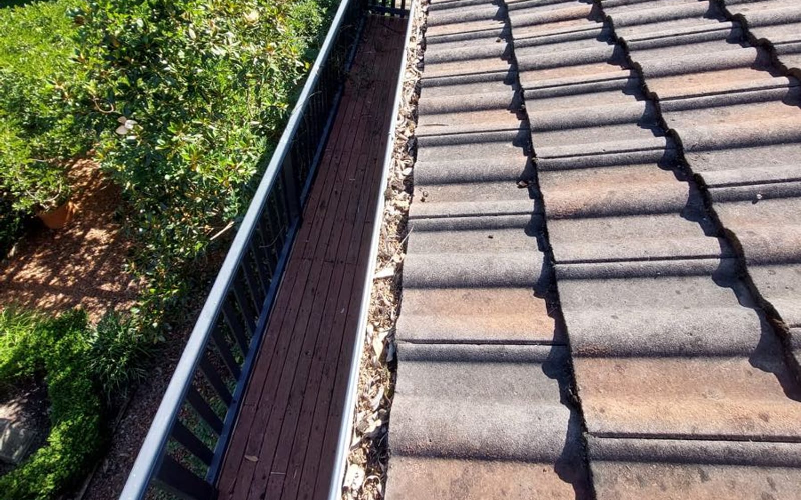 The same gutter run cleared and flowing after cleaning